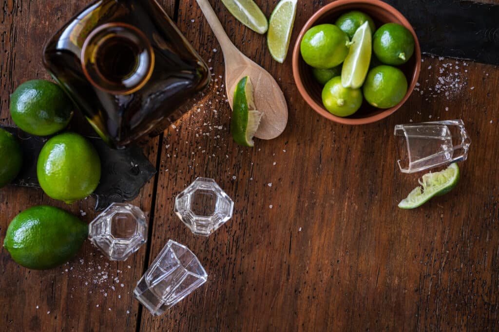 Ingredients to make a margarita on top of a cutting board.